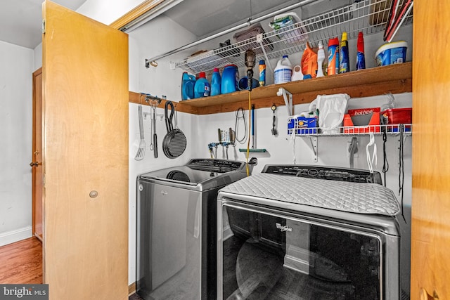 laundry area featuring laundry area, washer and dryer, baseboards, and wood finished floors