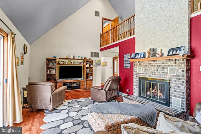 living area with visible vents, wood finished floors, and a fireplace