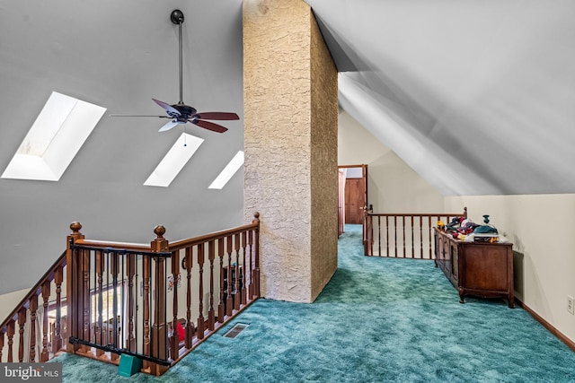 additional living space featuring lofted ceiling with skylight, visible vents, carpet floors, and ceiling fan