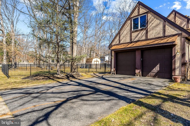 garage featuring driveway and fence