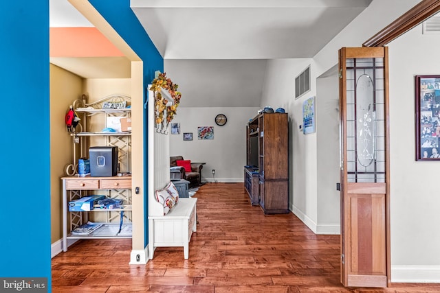 foyer entrance with wood finished floors, visible vents, and baseboards