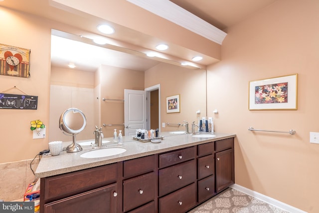 bathroom featuring double vanity, recessed lighting, a sink, and baseboards