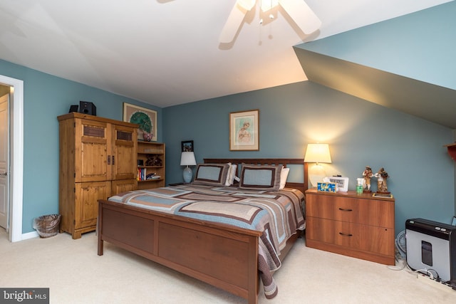 bedroom with light carpet, vaulted ceiling, and a ceiling fan