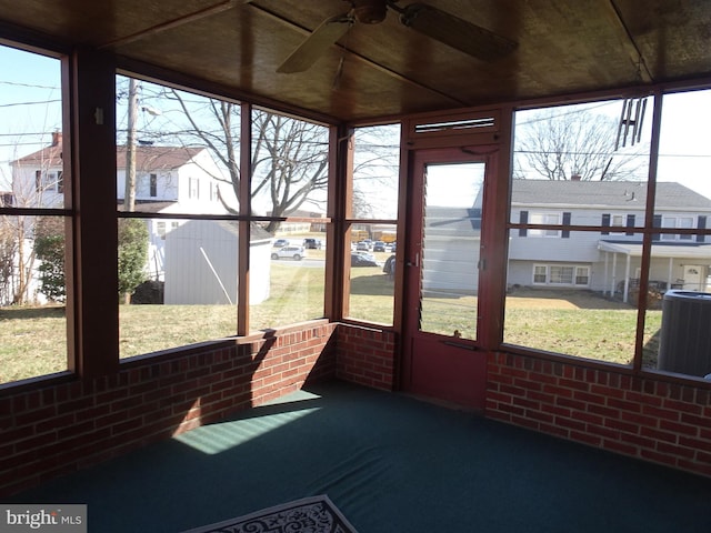 sunroom / solarium with a residential view and ceiling fan