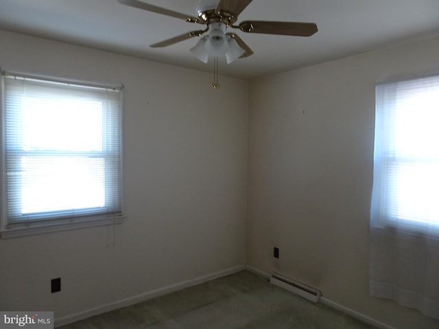 spare room featuring plenty of natural light, carpet floors, baseboards, and a baseboard radiator