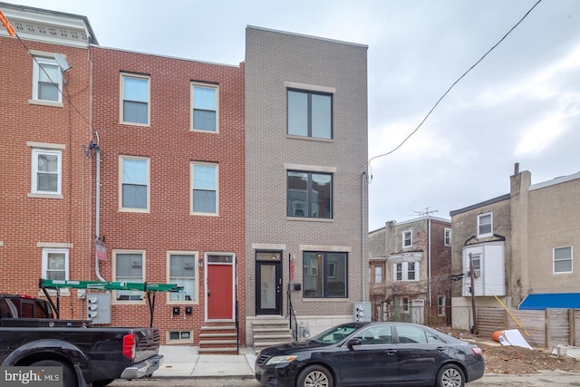 townhome / multi-family property featuring entry steps and brick siding