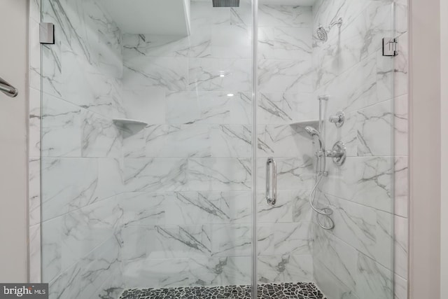 bathroom featuring a marble finish shower