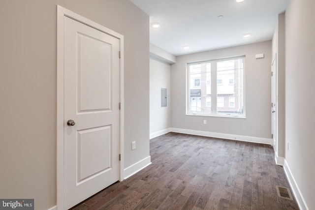 unfurnished bedroom with dark wood-style floors, electric panel, visible vents, and baseboards