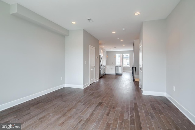 unfurnished living room featuring dark wood-type flooring and recessed lighting