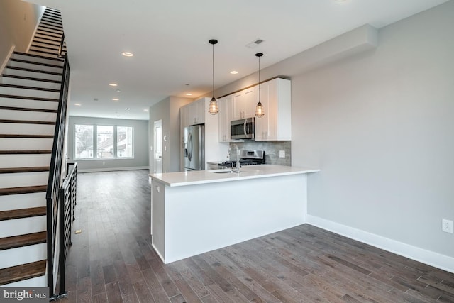 kitchen with visible vents, decorative backsplash, dark wood-style floors, stainless steel appliances, and white cabinetry