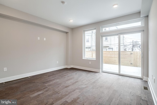 unfurnished room featuring recessed lighting, dark wood finished floors, visible vents, and baseboards