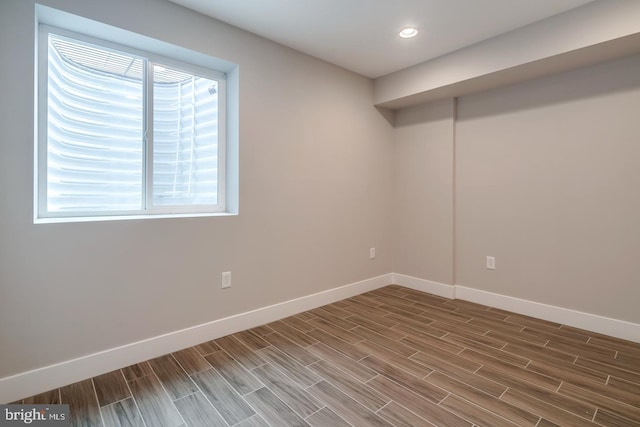 empty room with recessed lighting, wood tiled floor, and baseboards