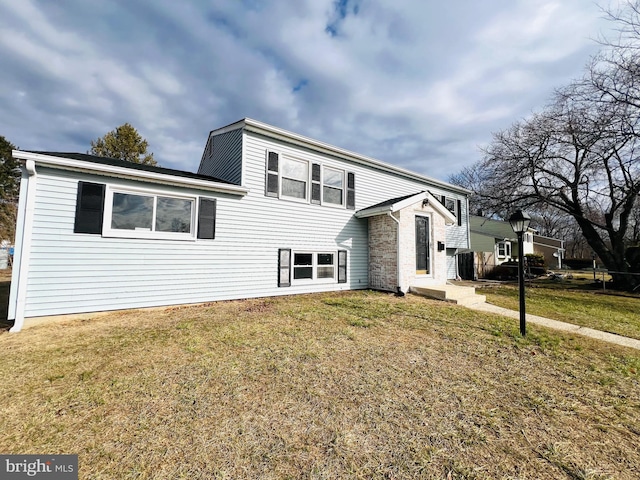 view of front of house featuring brick siding and a front lawn