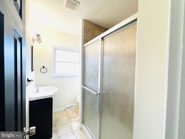 bathroom with toilet, a stall shower, visible vents, and vanity