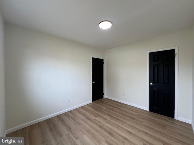 unfurnished room featuring light wood-type flooring and baseboards