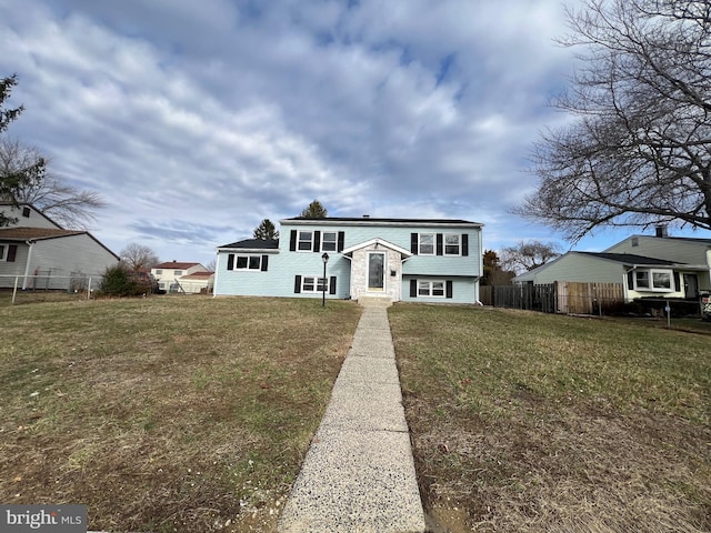 view of front facade featuring a front yard and fence