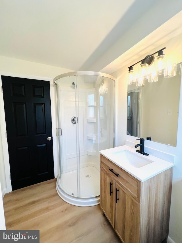 full bath featuring a stall shower, wood finished floors, and vanity