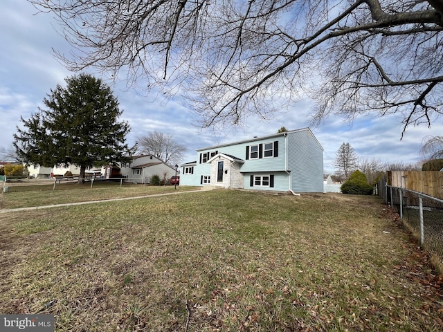 view of front of house with fence and a front lawn