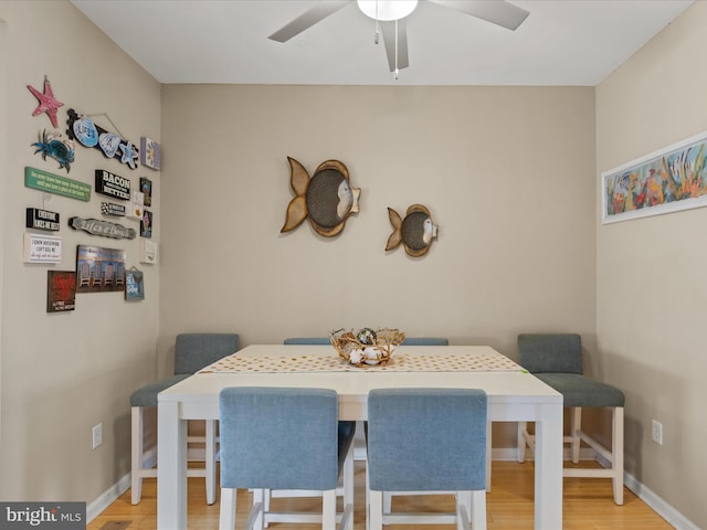 dining space featuring a ceiling fan, baseboards, breakfast area, and wood finished floors