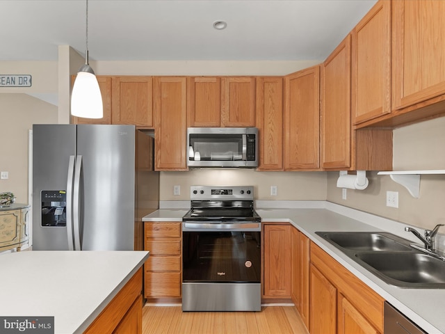 kitchen featuring stainless steel appliances, a sink, light countertops, open shelves, and pendant lighting