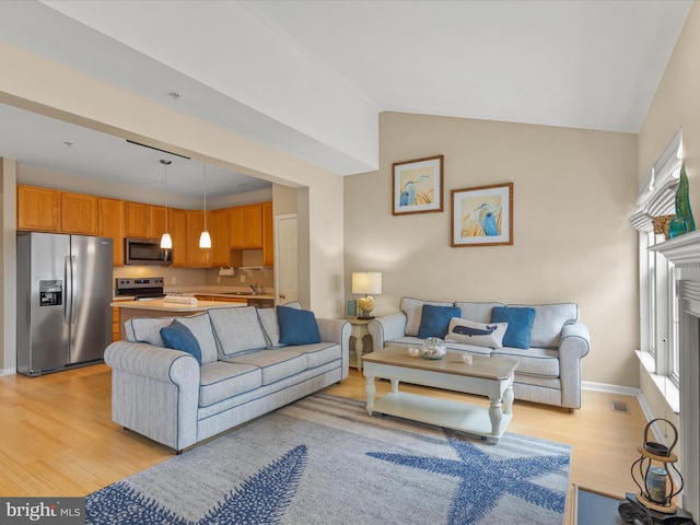 living room featuring light wood-style floors, baseboards, visible vents, and vaulted ceiling