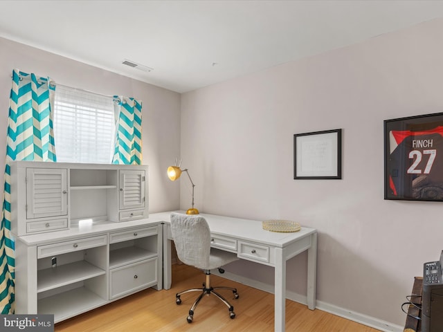 office featuring light wood finished floors, baseboards, and visible vents