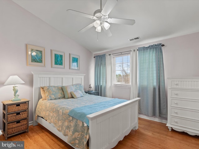 bedroom featuring lofted ceiling, visible vents, ceiling fan, and light wood finished floors