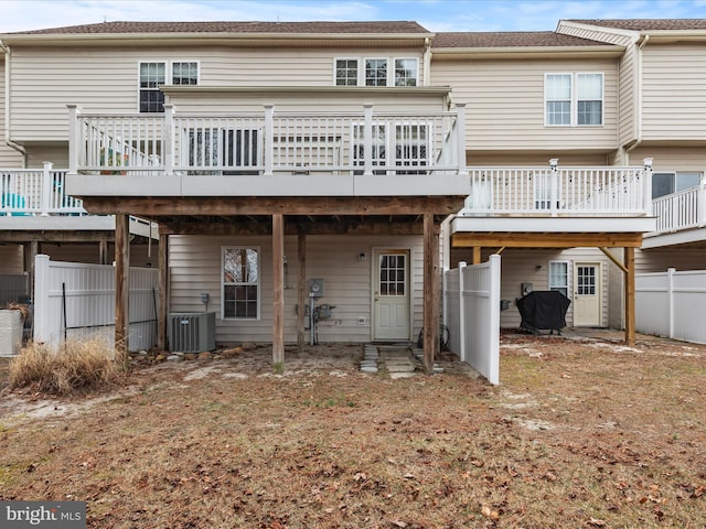 rear view of property featuring fence, a deck, and central AC