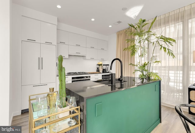 1500 Harry Thomas Way NE Unit 501, Washington, DC 20002 - kitchen with a center island with sink, white cabinetry, modern cabinets, and light wood-style floors