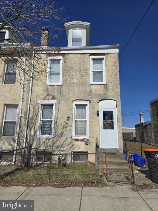 multi unit property with a fenced front yard and stucco siding