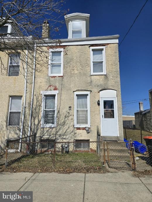 view of front facade featuring entry steps, a fenced front yard, and stucco siding