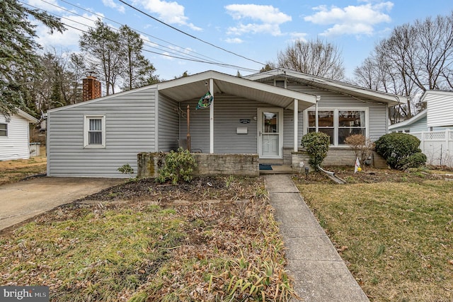 view of front of property with a chimney, fence, a porch, and a front yard