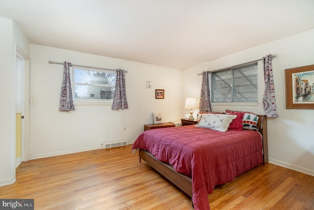 bedroom featuring visible vents, baseboards, and wood finished floors