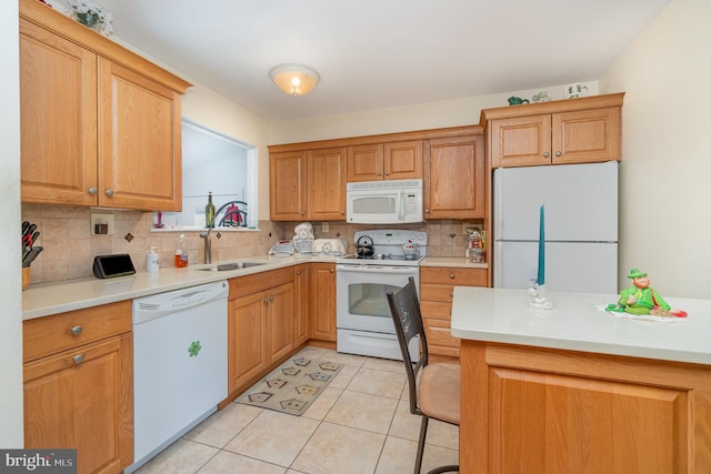 kitchen with light tile patterned floors, white appliances, a sink, light countertops, and decorative backsplash