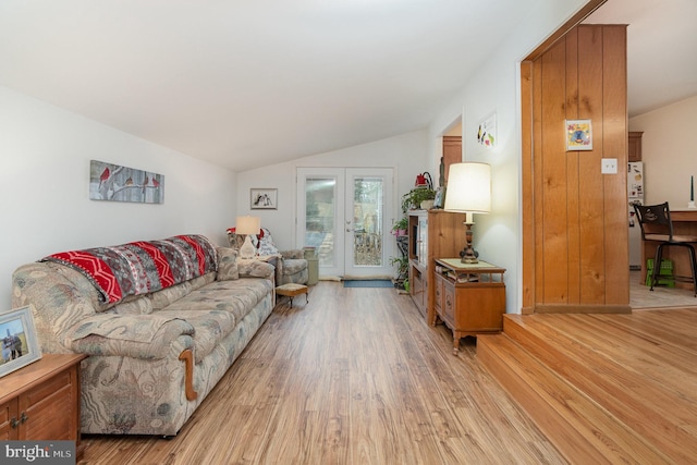 living area featuring lofted ceiling, french doors, and light wood finished floors