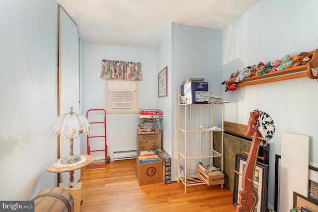 recreation room with baseboard heating and wood finished floors