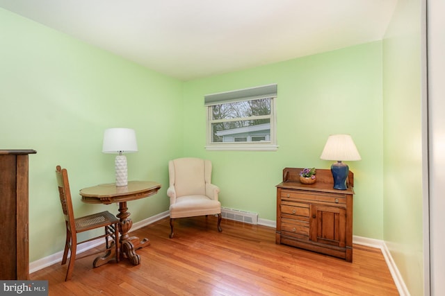 living area with light wood-type flooring, visible vents, and baseboards