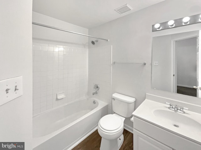 bathroom featuring shower / bathtub combination, visible vents, toilet, vanity, and wood finished floors