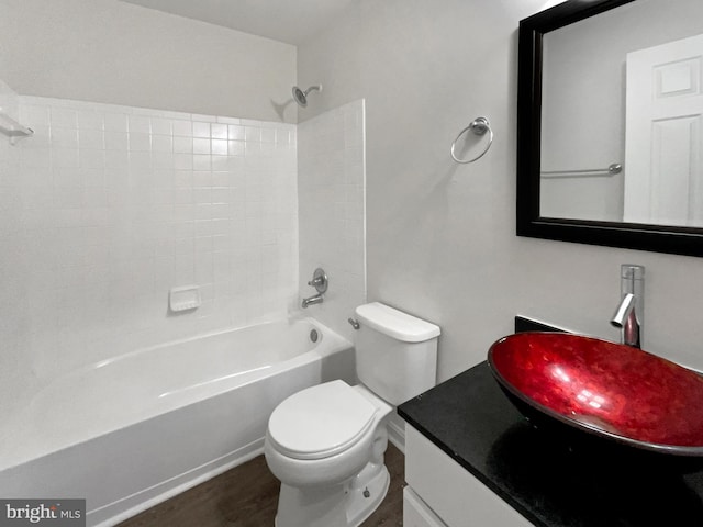 bathroom with toilet, tub / shower combination, wood finished floors, and vanity