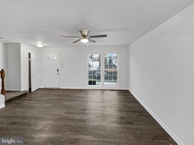 interior space with ceiling fan, baseboards, and dark wood-type flooring