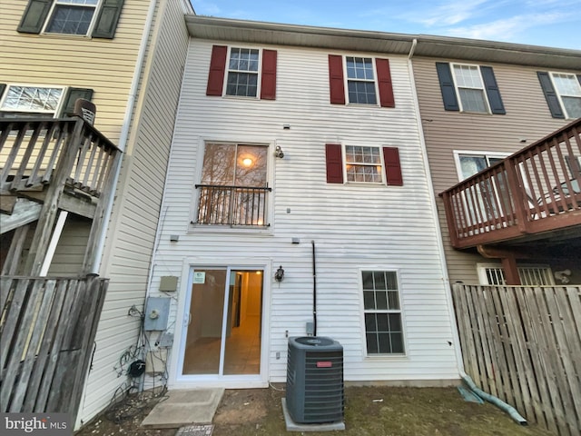 rear view of property with fence and central AC