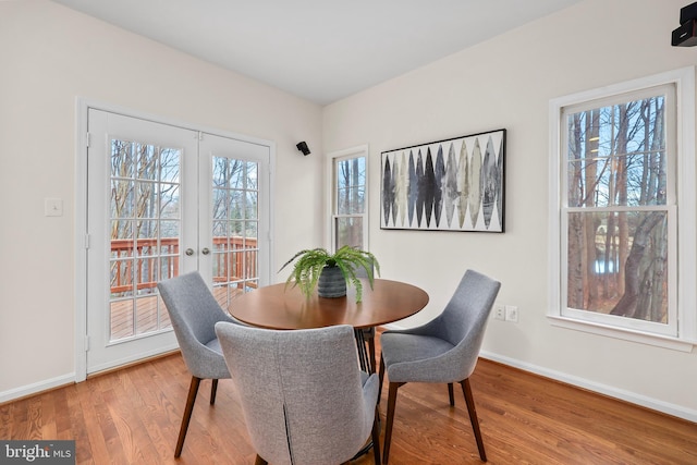 dining space featuring french doors, baseboards, and wood finished floors