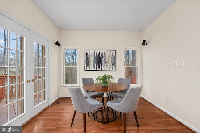 dining room featuring french doors, baseboards, and wood finished floors