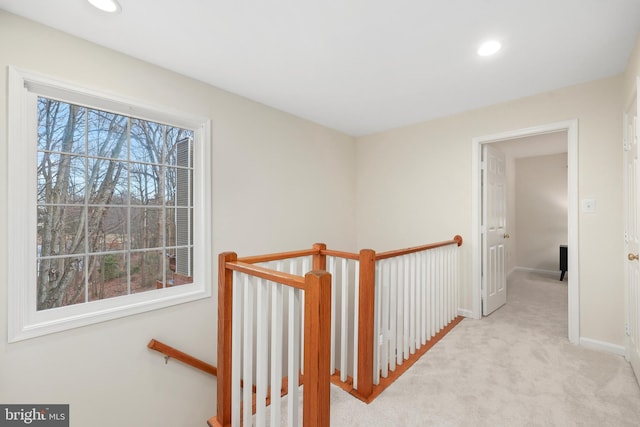 hall featuring a wealth of natural light, an upstairs landing, recessed lighting, and carpet flooring