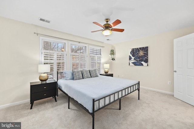 carpeted bedroom with visible vents, baseboards, and a ceiling fan