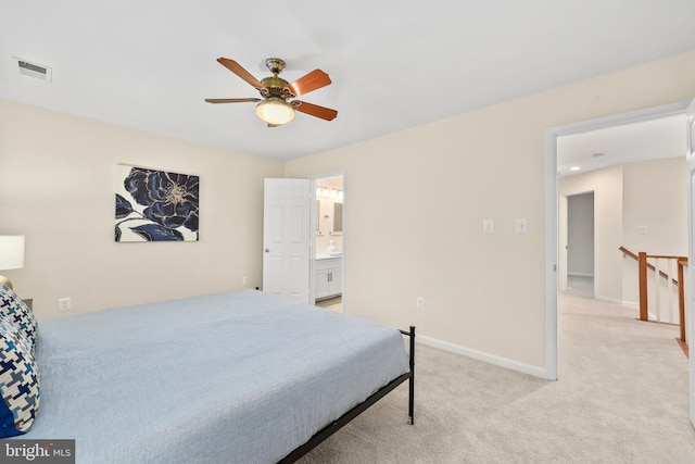 bedroom featuring a ceiling fan, visible vents, baseboards, ensuite bath, and light colored carpet