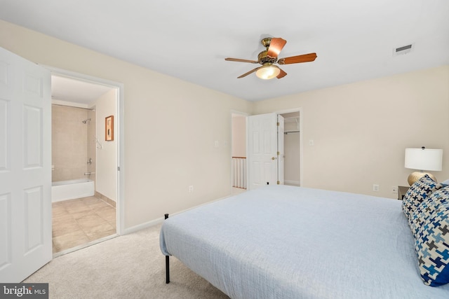 bedroom featuring visible vents, connected bathroom, baseboards, light carpet, and a ceiling fan