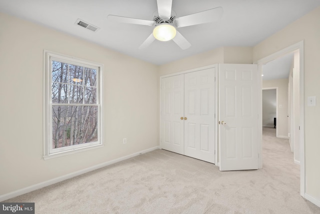 unfurnished bedroom featuring carpet, visible vents, a closet, and baseboards