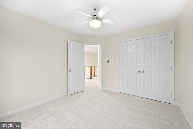 unfurnished bedroom featuring baseboards, carpet floors, a closet, and a ceiling fan