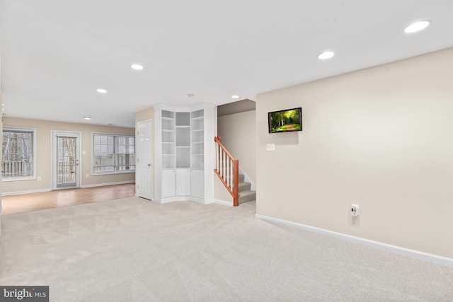 interior space featuring recessed lighting, stairway, baseboards, and light colored carpet